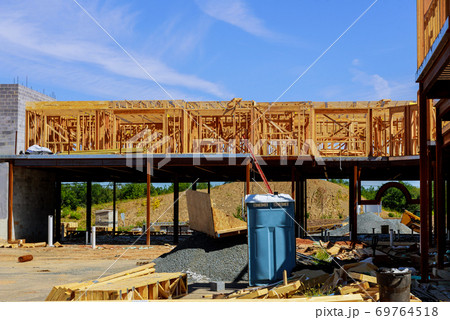 Framing beam of portable restroom on house under construction in a construction with garbage Framing beam of portable restroom on house under construction in a construction with garbage 69764518