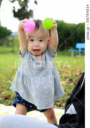 秋の公園で遊ぶ1歳の女の子 69764834