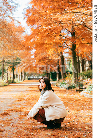 紅葉したラクウショウ並木と女性　 69764928