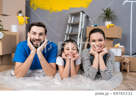 Happy family lying on bubble wrap planning. 69765232
