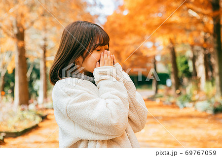 寒がる女性と紅葉 寒がる女性と紅葉 69767059