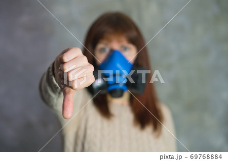 Girl in blue respirator stand on grey background. 69768884