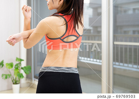 室内で運動する筋トレ女子 腕 肩のストレッチ ダイエット スポーツの写真素材