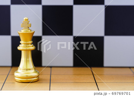 Gold king chess piece on wood chessboard 69769701