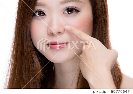 小鼻を指差す女性 69770647