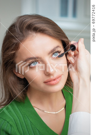 Makeup artist applying mascara on lashes 69772416