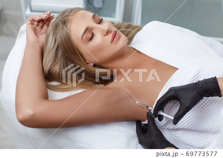 The doctor makes intramuscular injections of botulinum toxin 69773577