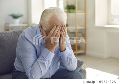 Elderly man, grieving about death of relative or forgotten by family, crying alone 69774123