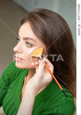 Make up artist applying professional make up of tonal foundation 69774480
