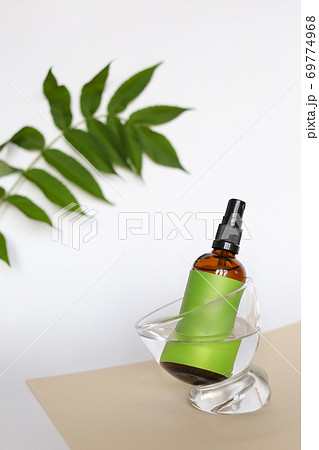 Close up glass bottle wirth cosmetic product and green space for brand near leaf. Close up glass bottle wirth cosmetic product and green space for brand near leaf. 69774968