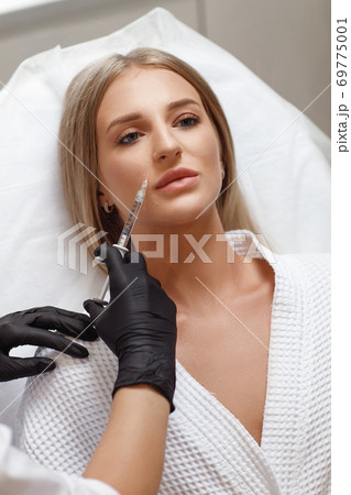 Enlarging lips, lip correction. Portrait white woman during an operation filling face wrinkles. Enlarging lips, lip correction. Portrait white woman during an operation filling face wrinkles. 69775001