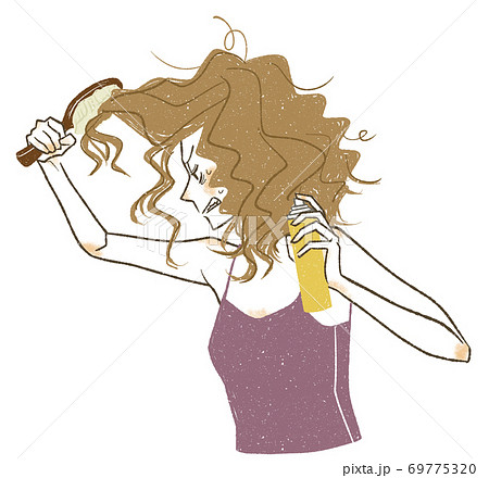 ダメージヘアに悪戦苦闘する女性 69775320