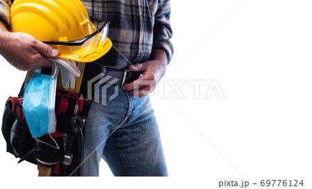 Carpenter with work tools and surgical mask on white background. Carpentry. Covid-19 prevention. Carpenter with work tools and surgical mask on white background. Carpentry. Covid-19 prevention. 69776124