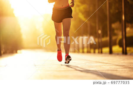 Anonymous sportswoman running in park. Anonymous sportswoman running in park. 69777035
