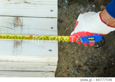 Measuring the length with a construction tape. Measuring the length with a construction tape. 69777546