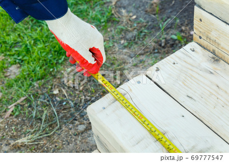 Measuring the length with a construction tape. Measuring the length with a construction tape. 69777547