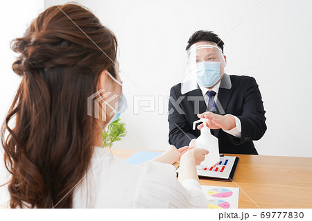 感染症予防のために手の消毒をするビジネスパーソン 69777830