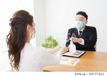 感染症予防のために手の消毒をするビジネスパーソン 69777832