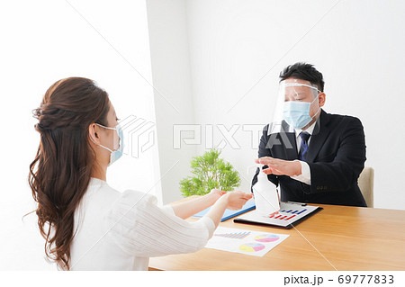 感染症予防のために手の消毒をするビジネスパーソン 69777833