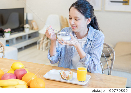 ヨーグルトを食べる若い女性 ヨーグルトを食べる若い女性 69779396