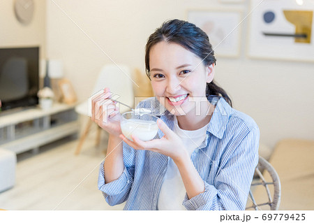 ヨーグルトを食べる若い女性 ヨーグルトを食べる若い女性 69779425