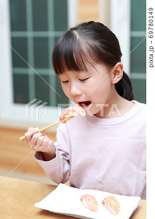 アトランティックサーモン 大西洋鮭 の握り寿司を食べる女の子の写真素材