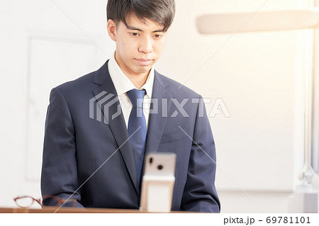 スマホでリモート面接を受けている男子学生 69781101