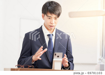 スマホでリモート面接を受けている男子学生 69781103