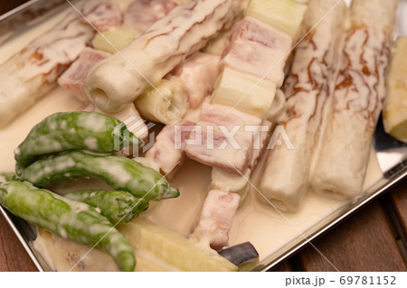 天ぷら衣をつけられた肉と野菜 69781152