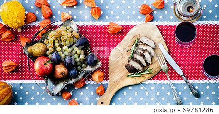 thanksgiving table with meat and fresh autumn fruits and vegetables thanksgiving table with meat and fresh autumn fruits and vegetables 69781286