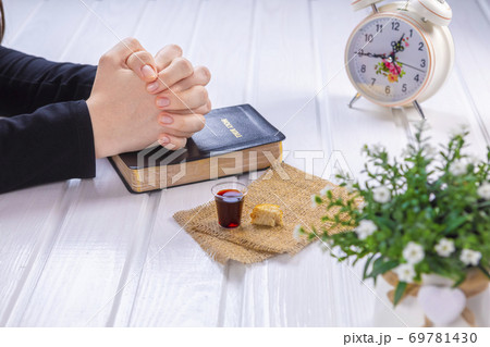 Young woman praying and Taking communion  - the wine and the bread symbols of Jesus Christ blood and body with Holy Bible 69781430