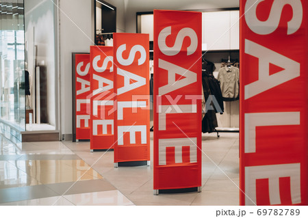 Red banners SALE on anti-thieft gate sensor at clothing store entrance. Black friday sale and seasonal discounts 69782789