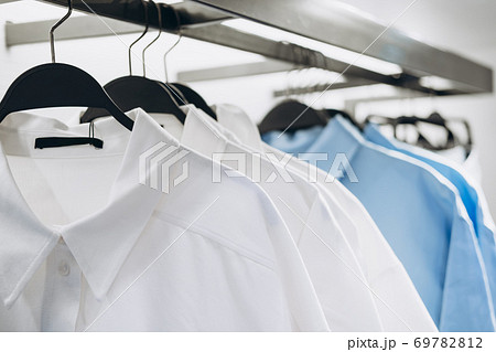 White and blue shirts on hangers in fashion store. Selective focus White and blue shirts on hangers in fashion store. Selective focus 69782812