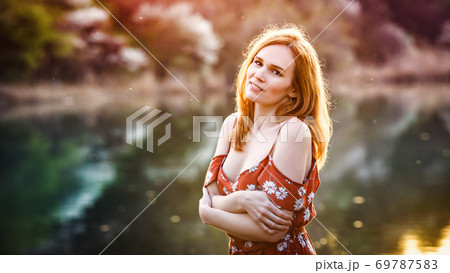 woman in dress bare shoulders on banks of river woman in dress bare shoulders on banks of river 69787583