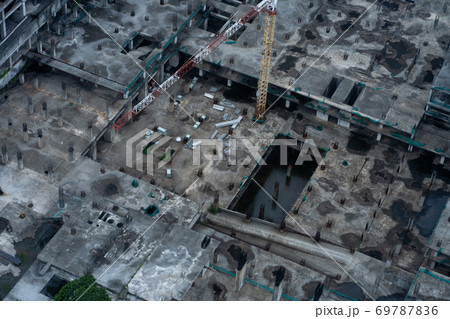 Top view of the construction site of a large building after rain. Piles are driven in and the lower floors are built. 69787836