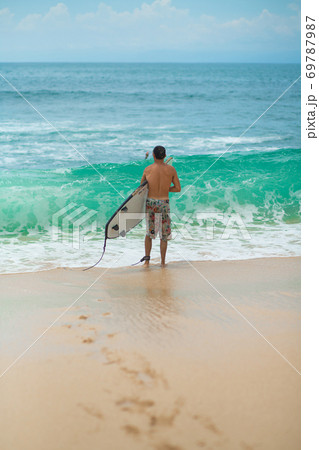 Surfer. Surfing Man With Surfboard Walking On Sandy tropical Beach. Healthy Lifestyle, water activities, Water Sport. Beautiful Ocean. Surfer. Surfing Man With Surfboard Walking On Sandy tropical Beach. Healthy Lifestyle, water activities, Water Sport. Beautiful Ocean. 69787987