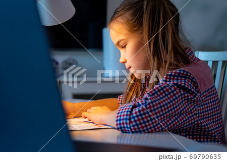 at night schoolgirl do homework, studying at home. 69790635