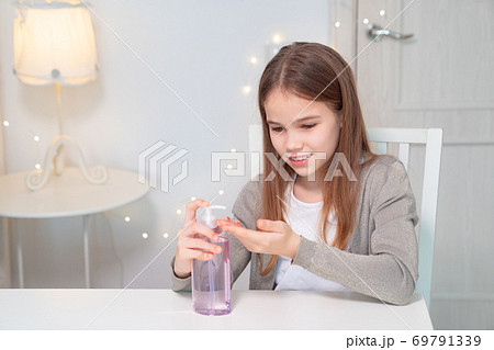girl uses disinfectant to clean their hands. girl uses disinfectant to clean their hands. 69791339