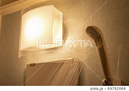琥珀色の照明と水を吹き出すシャワーヘッド	 69792068