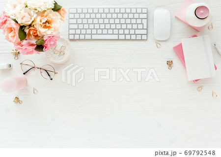Flat lay women's office desk. Female workspace with computer, pink roses flowers, accessories, golden diary, glasses on white background. Top view Flat lay women's office desk. Female workspace with computer, pink roses flowers, accessories, golden diary, glasses on white background. Top view 69792548