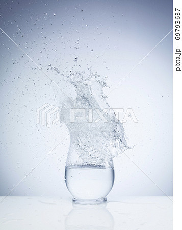 ガラスの容器に水の塊が落ちる瞬間の写真素材