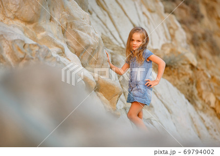 little girl standing on rock at sunset. travel. little girl standing on rock at sunset. travel. 69794002