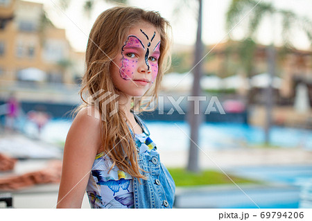 face painting pink butterfly on little girl  69794206
