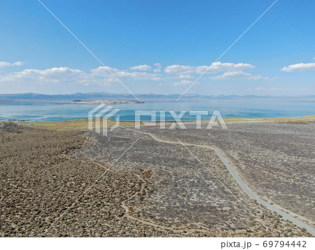 Aerial view of dusty dry desert land with Mono Lake on the background, Mono County 69794442