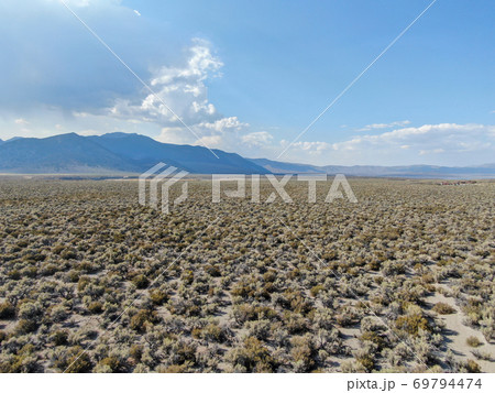 Aerial view of dusty dry desert land and mountain on the background in Lee Vining Aerial view of dusty dry desert land and mountain on the background in Lee Vining 69794474