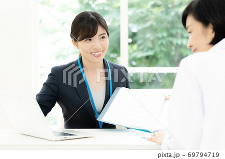 医師に情報提供するMR女性 69794719