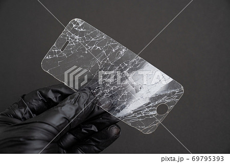 broken smartphone safety glass in black background 69795393