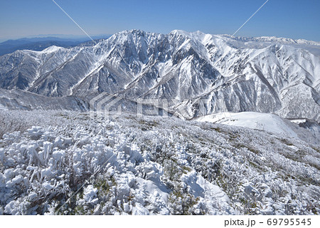 笠ヶ岳山頂近から見た樹氷の斜面と谷川岳東面岩壁、天神平スキー場方面 69795545
