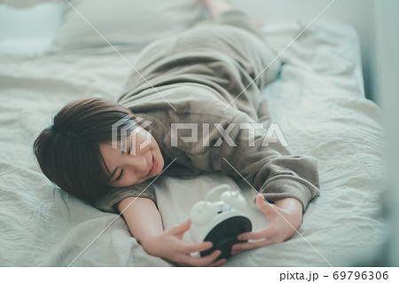 めざまし時計を止める30代女性 69796306