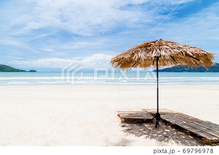 Beach Umbrella made of palm leafs on a perfect white beach in front of Sea. 69796978
